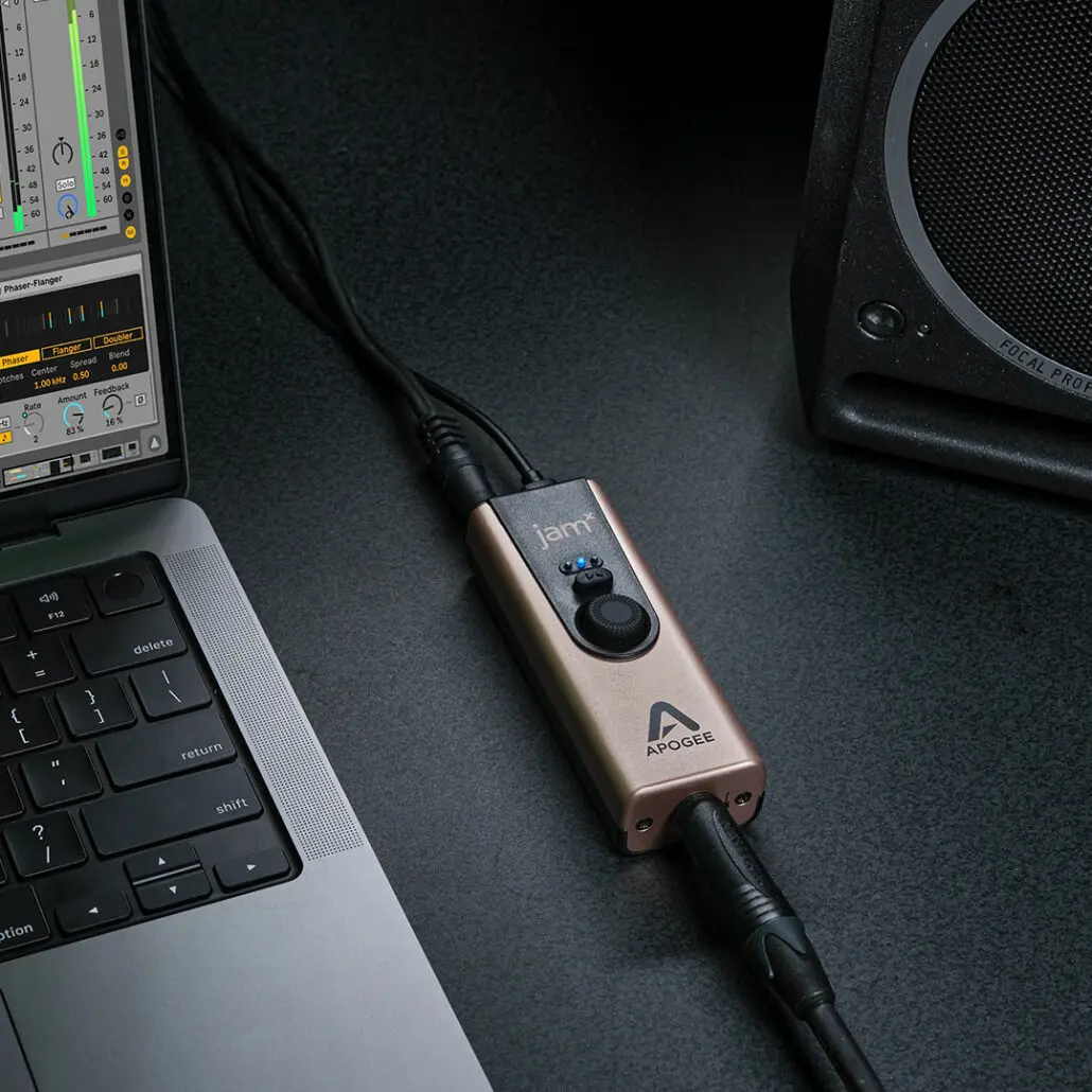 Jam X mobile guitar interface on a desk next to laptop